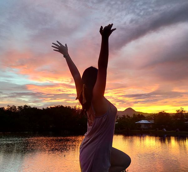 Silhouette of a person in a balanced pose against a serene background.